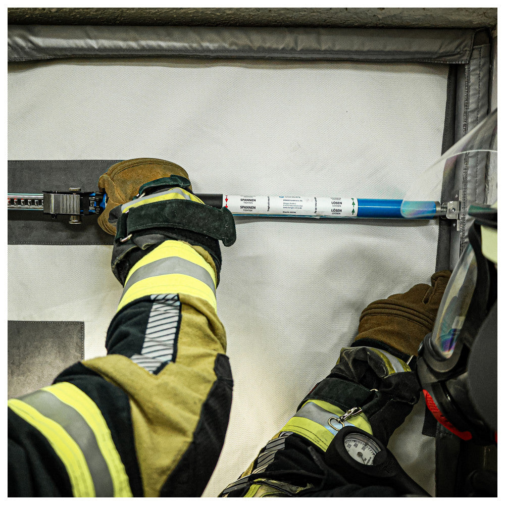 Feuerwehrleute installieren den Dönges Rauchschutzvorhang an einer Tür